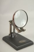 A BRONZE MAGNIFYING GLASS on a stand.