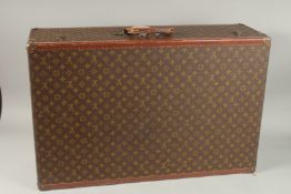 A LOUIS VUITTON SUITCASE with leather handle and brass mounts. 80cms long x 50cms wide x 25cms