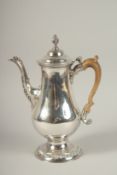 A GEORGE III SILVER COFFEE POT with wooden handle. London 1773. Maker: John King. Gross weight: