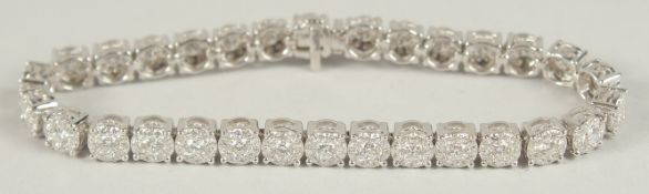 A SUPERB 18CT WHITE GOLD CLUSTER OF THIRTY DIAMONDS FORMING A LINE BRACELET.