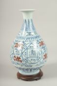 A CHINESE UNDER-GLAZE RED, BLUE AND WHITE VASE with wooden stand. Vase 31cms high.