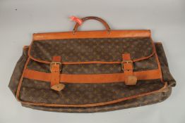 A LOUIS VUITTON FOLDING LEATHER BAG with leather handle, brass and leather straps. 73cms long x