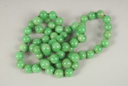 A STRING OF JADE BEADS. 90cms long.