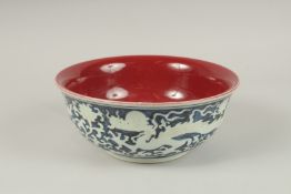 A CHINESE BLUE AND WHITE DRAGON BOWL, with copper red interior. 26.5cms diameter.