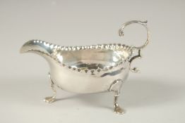 A SMALL GEORGE III SILVER SAUCEBOAT on three pad feet. London 1769.