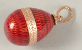 A RUSSIAN 14CT GOLD RED ENAMEL EGG PENDANT.