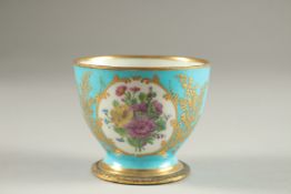 A GOOD SMALL SEVRES PALE BLUE GROUND BOWL, edged in gilt with two panels of flowers. 7cms high. Mark
