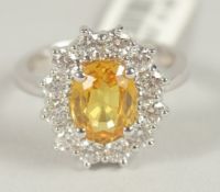 A GOOD 18CT WHITE GOLD YELLOW SAPPHIRE AND DIAMOND CLUSTER RING. Note: Never worn. Retail price £4,