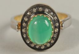 A CABOCHON GREEN ONYX AND DIAMOND HALO RING, set in silver. Onyx 1.91ct. Diamonds 0.22ct.