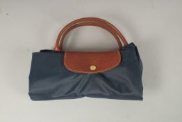 A LONGCHAMP BLUE FABRIC FOLDING BAG. 28cms x 15cms closed.