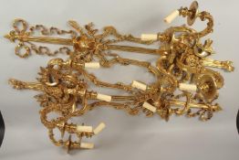 A GOOD PAIR OF LARGE FOUR-LIGHT GILT BRONZE WALL SCONCES with ribbon motifs, masks and acanthus.