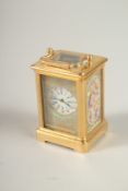 A TINY BRASS CARRIAGE CLOCK with pink porcelain sides. 6cms high.