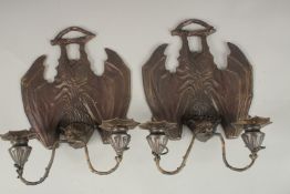 A PAIR OF BRONZE BAT WING TWO-LIGHT WALL SCONCES. 33cms.