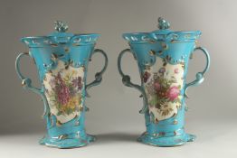 A PAIR OF SEVRES DESIGN BLUE GROUND, TWO HANDLED VASES with reverse panels of flowers. 33cms high.
