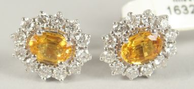 A GOOD PAIR OF 18CT WHITE GOLD YELLOW SAPPHIRE AND DIAMOND CLUSTER EARRINGS. Note: Never worn.