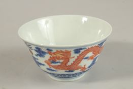A CHINESE BLUE AND WHITE WITH COPPER RED DRAGON TEA BOWL, six-character mark to base, 11cm