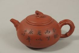 A CHINESE SQUAT-FORM YIXING TEAPOT, with incised flora and calligraphy, the lid with foo dog finial,