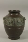 A CHINESE BRONZE TWIN HANDLE VASE, with relief band of archaic decoration, 23cm high.
