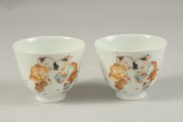 A PAIR OF CHINESE POLYCHROME PORCELAIN TEA CUPS, painted with boys playing, the base with red