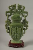 A LARGE CHINESE CARVED JADE LIDDED VASE, with twin drop ring handles and carved with dog of o,