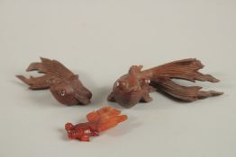 TWO CHINESE CARVED WOOD FISH, together with a small carved stone fish, (3).