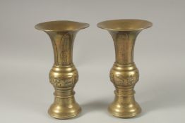A PAIR OF CHINESE BRASS TRUMPET FORM VASES, with archaic style designs, the bases with indistinct