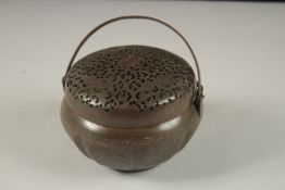 A CHINESE METAL HAND WARMER, with pierced cover, 15cm diameter.