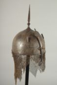 A FINE PERSIAN QAJAR ENGRAVED STEEL HELMET, with traces of gilding, the front with retractable