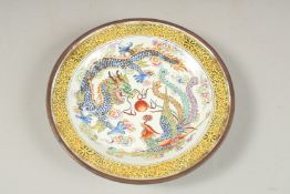 A CHINESE ENAMELLED DRAGON AND PHOENIX DISH, base with character mark, 13.5cm diameter.
