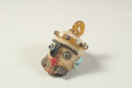 AN UNUSUAL GLASS HEAD-SHAPED BEAD.