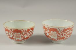 A PAIR OF CHINESE COPPER RED AND WHITE PORCELAIN BOWLS, with bats and longevity symbols, 10cm