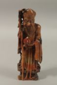 A CHINESE CARVED RED SOAPSTONE FIGURE OF SHOU LAO, 27cm high.