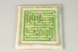 A VERY FINE AND UNUSUAL PERSIAN SAFAVID WHITE AND GREEN GLAZED POTTERY TILE, with raised Kufic