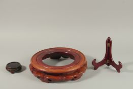 THREE CHINESE WOODEN STANDS, largest stand: circular surface to fit a base of 29cm, (3).