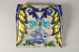 A FINE AND UNUSUAL 19TH CENTURY INDIAN GLAZED POTTERY TILE, with raised moulded floral decoration,