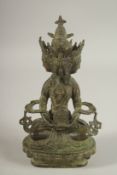 A FIGURE OF A SEATED MULTI-HEADED DEITY, 22cm high.