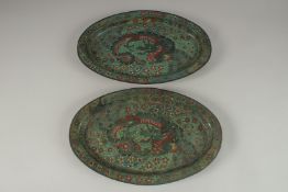 A PAIR OF CHINESE GREEN GROUND CLOISONNE OVAL DRAGON DISHES, 38cm x 24.5cm.