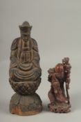 A CHINESE CARVED WOOD BUDDHA SEATED UPON A LOTUS BASE, with traces of gilt, 31cm high, together with