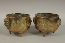 A PAIR OF 19TH CENTURY CHINESE GILT BRONZE TRIPOD CENSERS, with lion-form handles and calligraphy