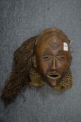 A good carved wood tribal mask with straw hair and woven neck collar.
