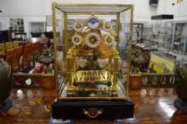 A congreve rolling ball clock in a glass case with key (lacking ball).