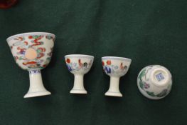 A pair of miniature Chinese Doucai style pedestal cups together with a similar larger cup and a