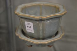 A Chinese celadon glazed jardiniere and stand.