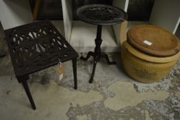 Two cast iron trivets/stands together with a bread crock with wooden cover.
