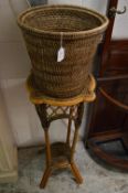 A waste paper basket, bamboo jardiniere stand and a jardiniere containing a artificial fern.