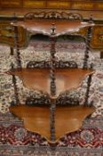 A rosewood three tier whatnot of shaped outline.