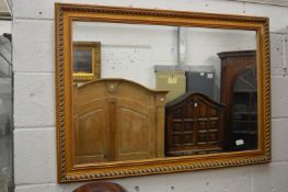 A modern gilt framed rectangular wall mirror.