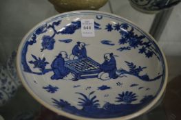Chinese blue and white circular dish decorated with seated figures playing a game.