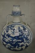 A Chinese blue and white moon flask decorated with dragons.