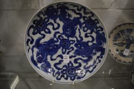 A large Chinese blue and white circular dish decorated with lion dogs.